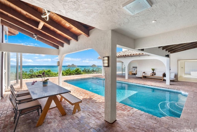 pool with a patio area and a water view