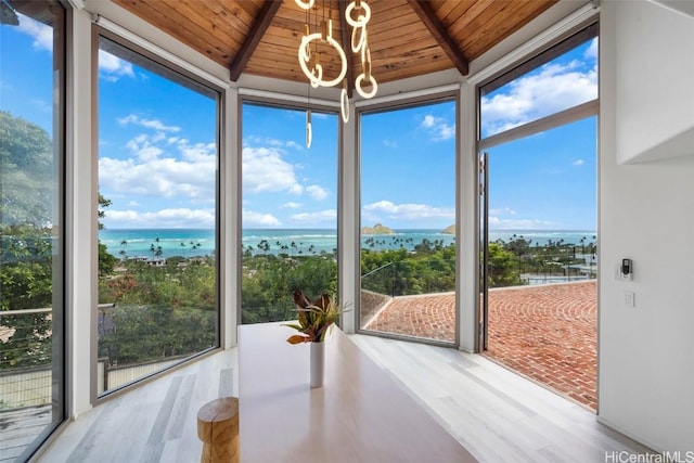 unfurnished sunroom with wooden ceiling, a water view, and vaulted ceiling