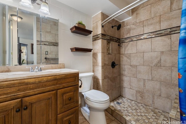 full bathroom featuring tiled shower and toilet