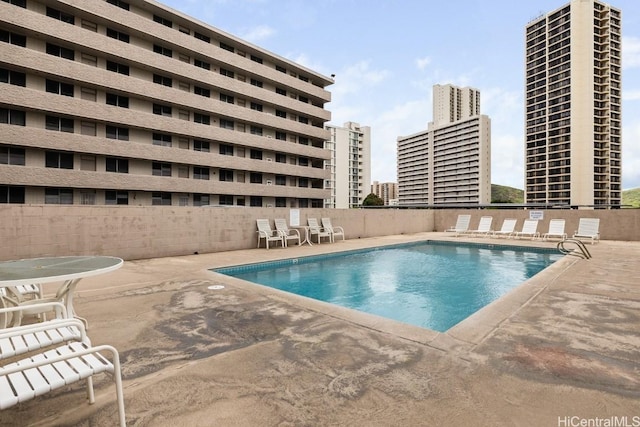 community pool with a city view and a patio area