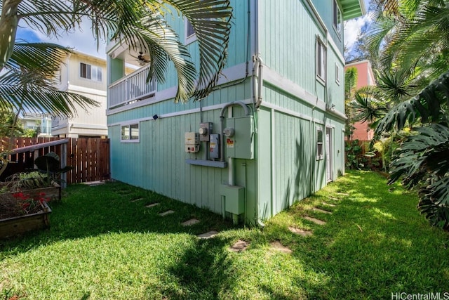 view of property exterior with a lawn and fence