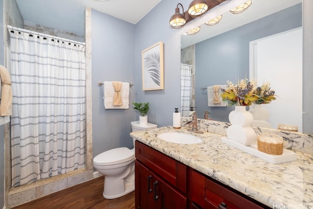 bathroom with vanity, curtained shower, toilet, and wood finished floors