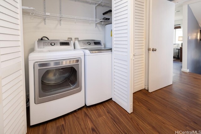 laundry area featuring washing machine and clothes dryer, laundry area, and dark wood finished floors