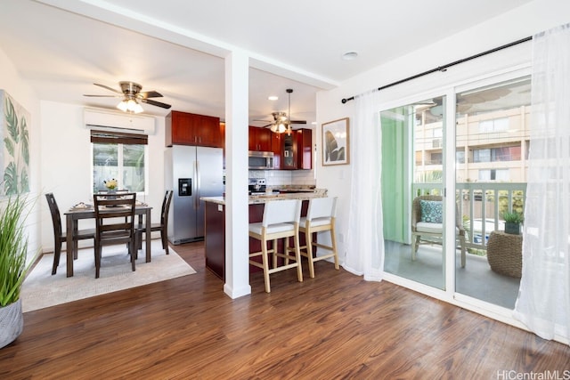 kitchen with stainless steel appliances, dark brown cabinets, dark wood-style flooring, and light countertops