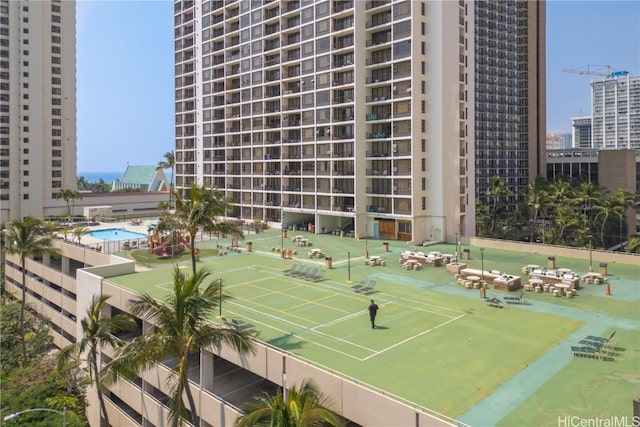 view of tennis court with a view of city