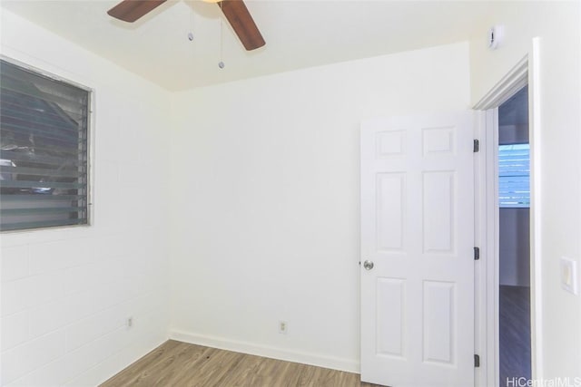 empty room with wood finished floors, baseboards, and ceiling fan