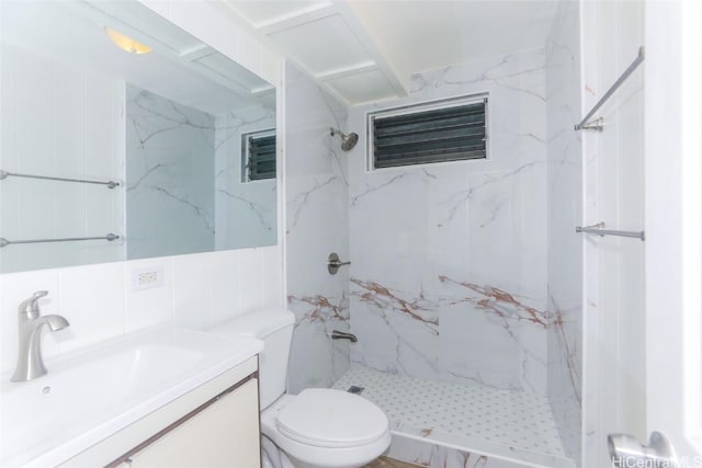 bathroom featuring a marble finish shower, toilet, tile walls, and vanity