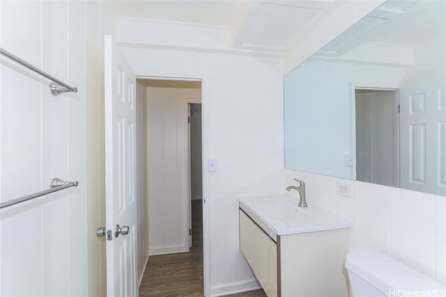 bathroom featuring vanity, toilet, and wood finished floors