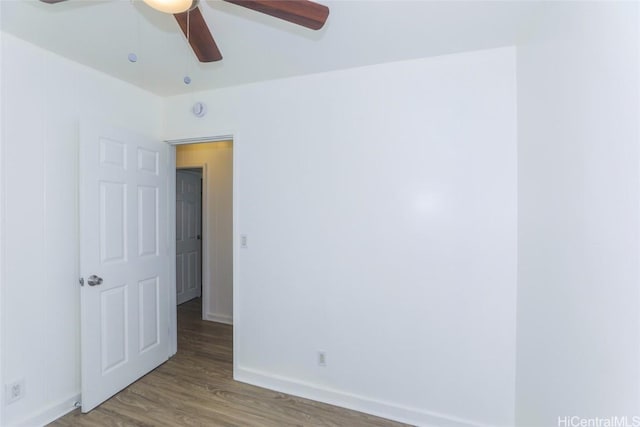 unfurnished room with baseboards, wood finished floors, and a ceiling fan