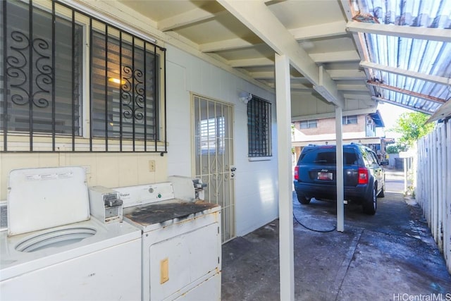 exterior space with a carport, washing machine and dryer, and fence