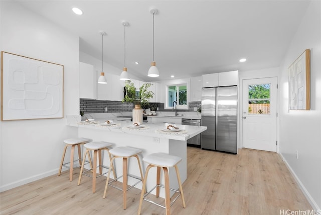 91-1046 Kauiki St, Ewa Beach, HI 96706 - kitchen featuring a breakfast bar, a peninsula, a sink, stainless steel appliances, and white cabinetry