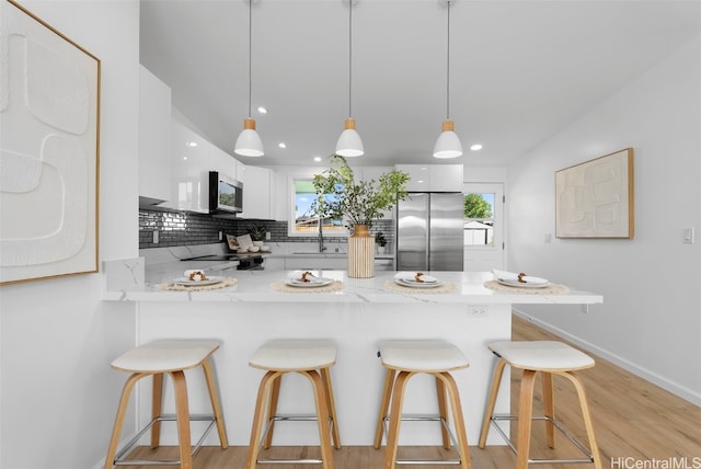 91-1046 Kauiki St, Ewa Beach, HI 96706 - kitchen with white cabinetry, a peninsula, modern cabinets, and appliances with stainless steel finishes