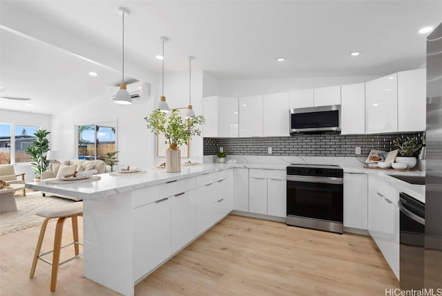 91-1046 Kauiki St, Ewa Beach, HI 96706 - kitchen with range with electric cooktop, modern cabinets, an AC wall unit, stainless steel microwave, and a peninsula