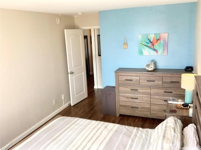 bedroom with dark wood-style floors and baseboards