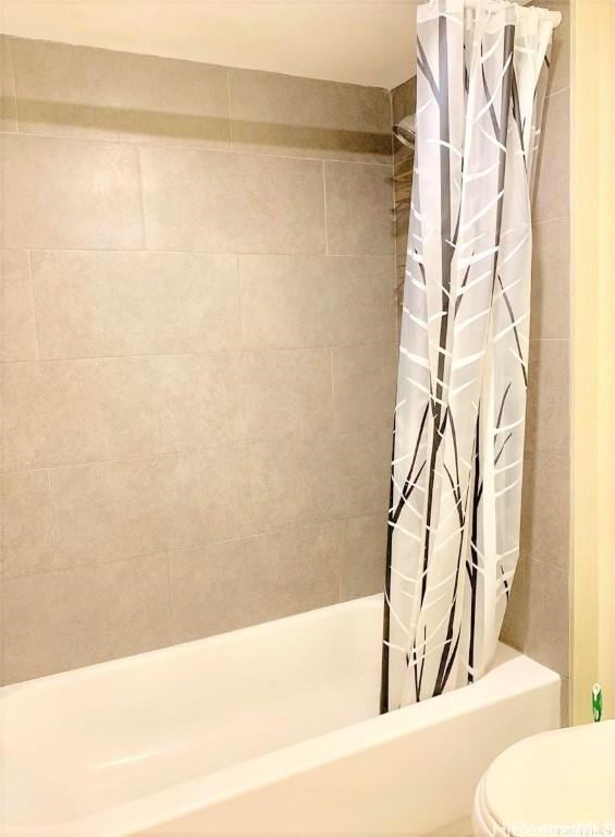 bathroom with toilet and shower / bath combo with shower curtain