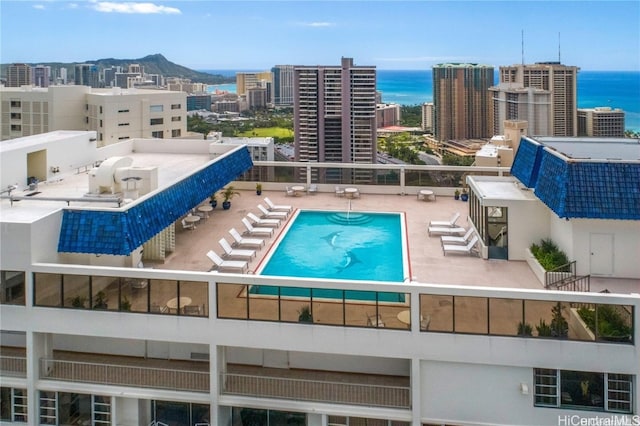 community pool with a view of city, a patio, and a water view