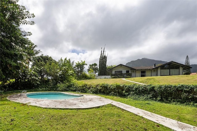 outdoor pool featuring a yard