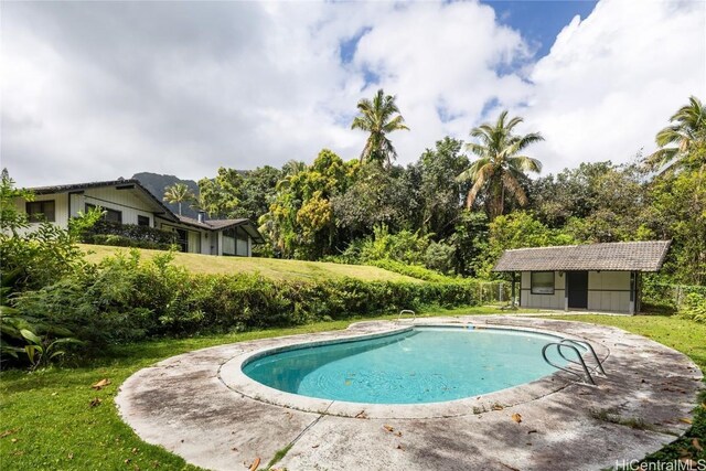 outdoor pool with a patio and a yard