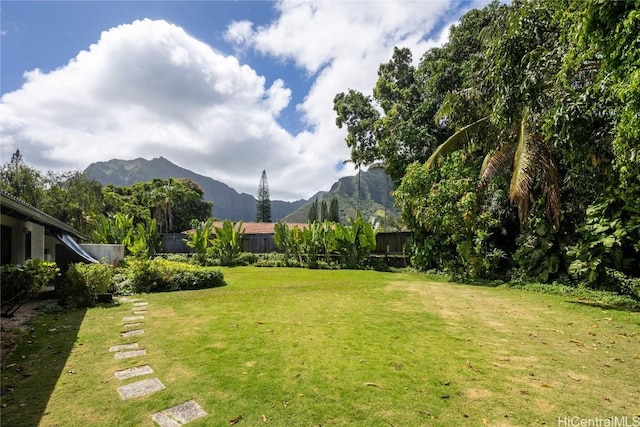 view of yard featuring a mountain view and fence