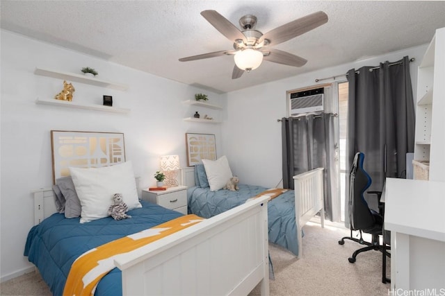 bedroom featuring light colored carpet, a textured ceiling, a wall unit AC, and a ceiling fan