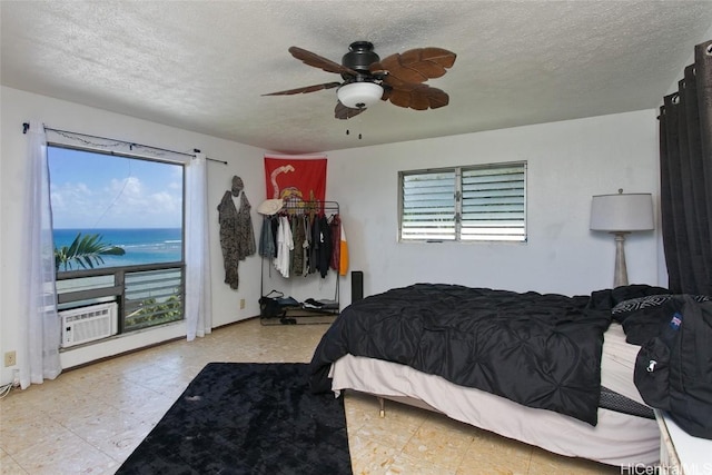 bedroom featuring cooling unit, multiple windows, a textured ceiling, and ceiling fan