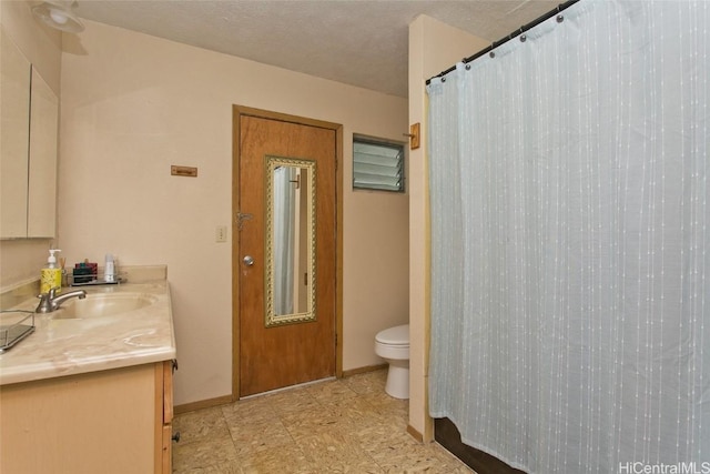 bathroom with baseboards, toilet, a shower with shower curtain, vanity, and a textured ceiling