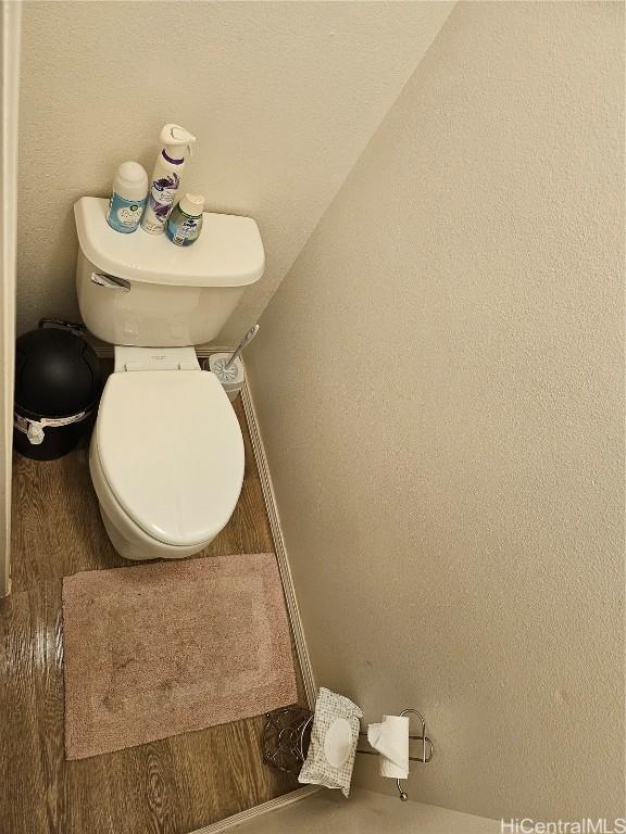 bathroom featuring toilet and a textured wall