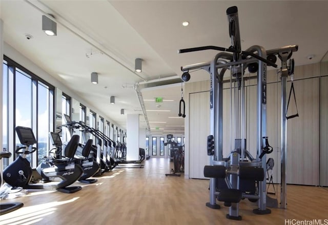 gym with a healthy amount of sunlight and wood finished floors