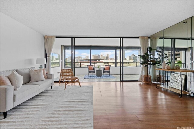 581 Kamoku St Unit 504, Honolulu, HI 96826 - living area featuring a view of skyline, expansive windows, wood finished floors, and a textured ceiling