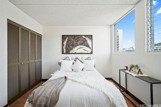 bedroom featuring a closet, a textured ceiling, and wood finished floors