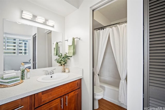 bathroom featuring vanity, toilet, wood finished floors, and shower / bath combo