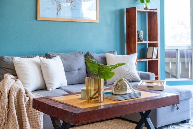 living area with a textured wall and wood finished floors