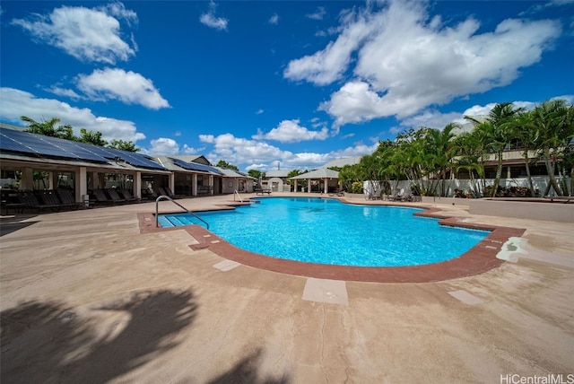 community pool with a patio and fence