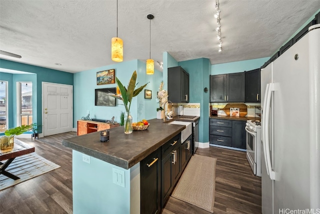 kitchen featuring white appliances, dark wood-style floors, dark countertops, and a textured ceiling