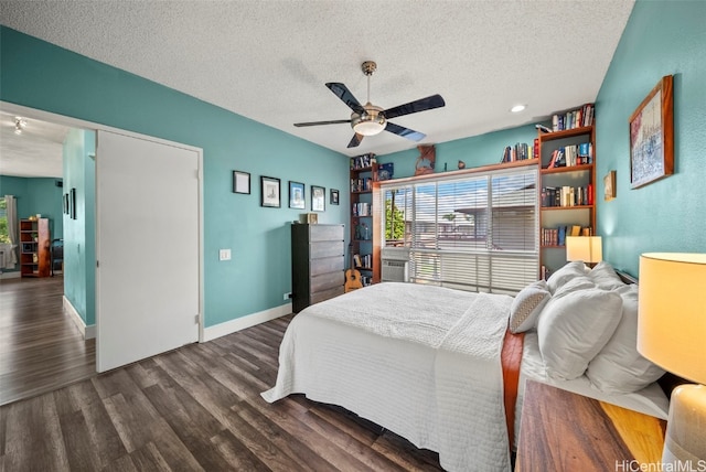 bedroom with a textured ceiling, a ceiling fan, baseboards, and wood finished floors