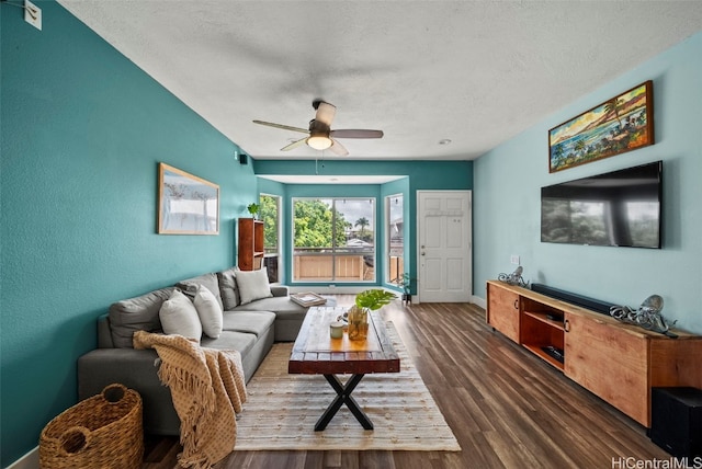 living area with baseboards, a textured ceiling, wood finished floors, and a ceiling fan