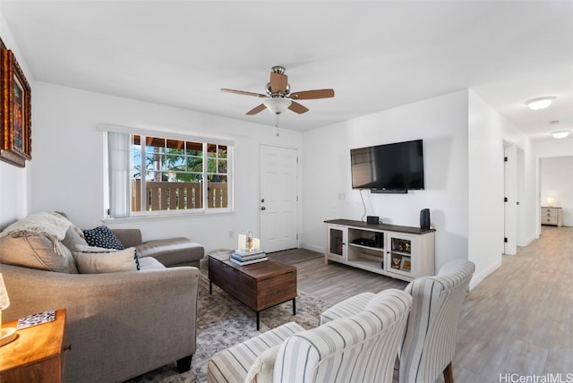 living room with wood finished floors, baseboards, and ceiling fan