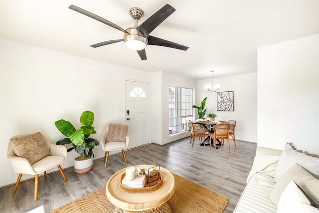 entryway featuring light wood-style flooring and ceiling fan with notable chandelier