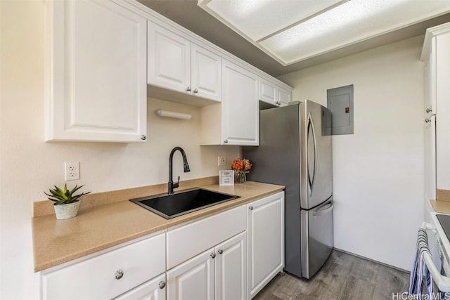 kitchen featuring dark wood finished floors, white cabinets, light countertops, and a sink