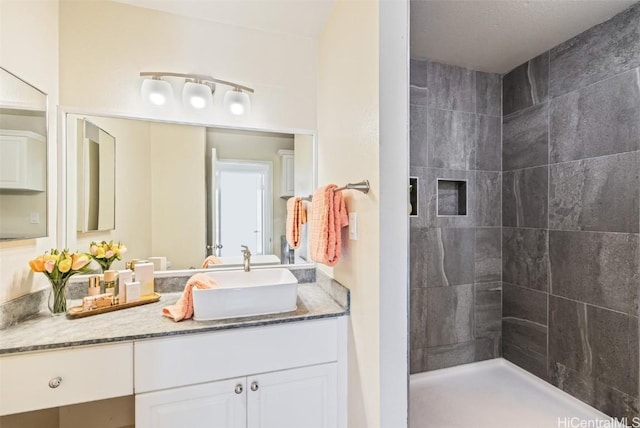 bathroom with vanity and a tile shower