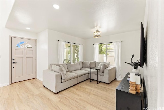 living room featuring recessed lighting, baseboards, and light wood-style flooring