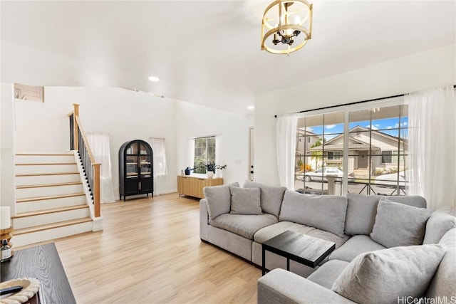 living area with light wood-type flooring, stairway, lofted ceiling, and recessed lighting