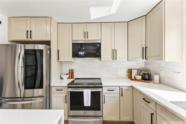 kitchen featuring decorative backsplash, appliances with stainless steel finishes, cream cabinets, and light countertops