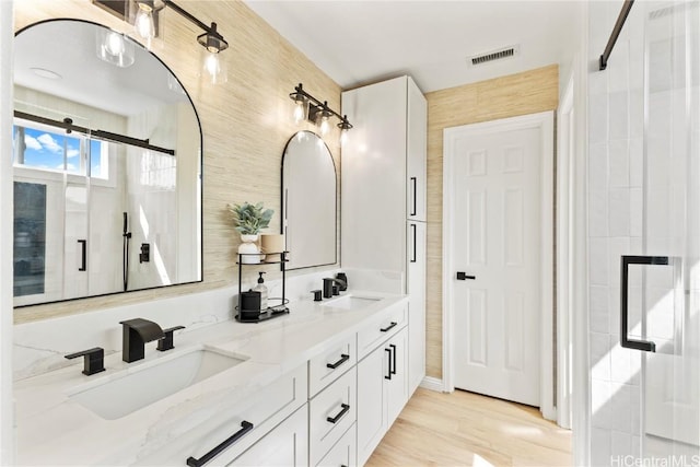 bathroom featuring double vanity, visible vents, tile walls, and a sink