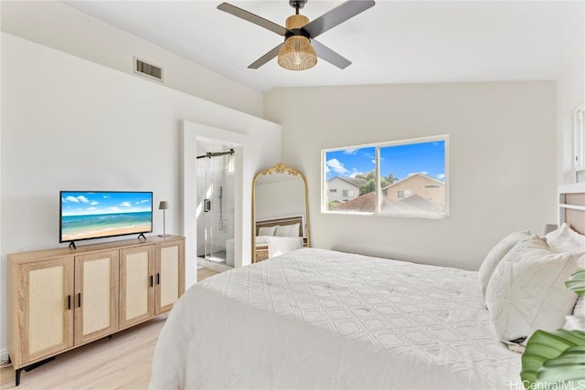 bedroom featuring visible vents, ceiling fan, lofted ceiling, ensuite bathroom, and light wood-style floors