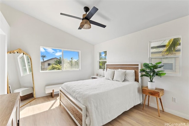 bedroom featuring baseboards, lofted ceiling, light wood-style floors, and a ceiling fan