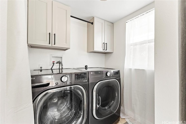 washroom with cabinet space and separate washer and dryer