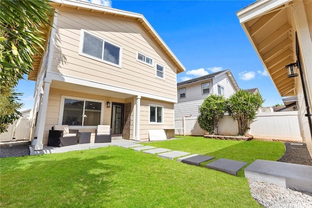 rear view of property featuring a lawn and a fenced backyard