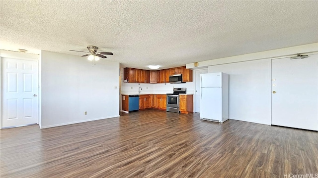 kitchen with dark wood-style floors, appliances with stainless steel finishes, brown cabinetry, light countertops, and ceiling fan