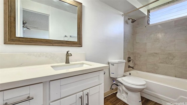 full bathroom with toilet, vanity, wood finished floors, washtub / shower combination, and a ceiling fan